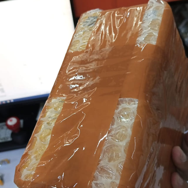 Sudut kardus diberi lapisan bubble wrap tambahan sebelum lakban terakhir ditempel